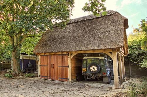Thatched oak framed barn building with room above.
